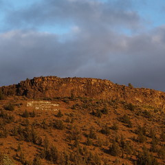 A Butte in Central Oregon with a golden glow as the sun sets for the day.