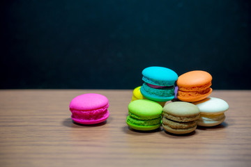 macarons on black floor and brick wall background. candy, bakery and kitchen. frence dessert. luxury sweets of france.image for background, wallpaper and copy space,