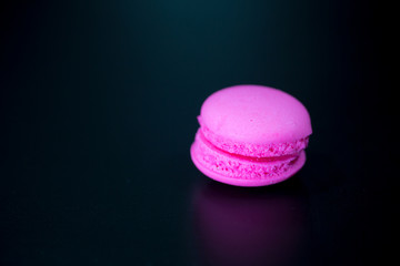 macarons on black floor and brick wall background. candy, bakery and kitchen. frence dessert. luxury sweets of france.image for background, wallpaper and copy space,