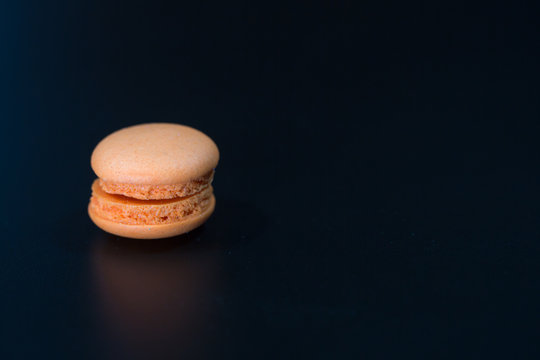 macarons on black floor and brick wall background. candy, bakery and kitchen. frence dessert. luxury sweets of france.image for background, wallpaper and copy space,