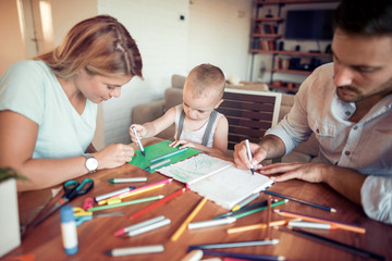 Young parents with son drawing