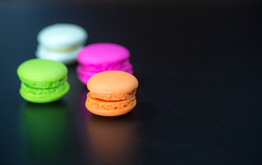macarons on black floor and brick wall background. candy, bakery and kitchen. frence dessert. luxury sweets of france.image for background, wallpaper and copy space,