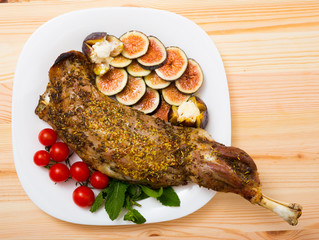 Tasty shoulder of lamb baked in oven with honey, served  with fig, feta cheese and herbs