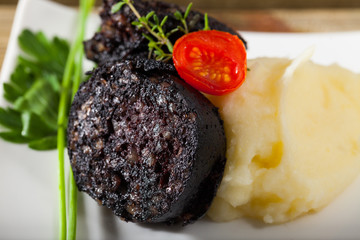 Tasty  blood sausage with mashed potato and greens, served at plate