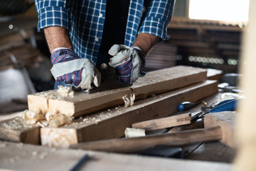 Close-up men hands in gloves with the planer handles wood Board, manual labour, diy, workflow