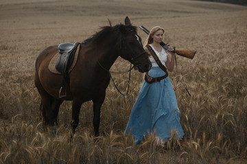 Portrait of a beautiful female cowgirl with shotgun from wild west riding a horse in the outback.