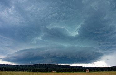 beautiful sky with clouds over the field near the forest