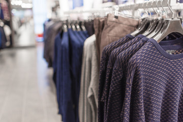 Men's sweaters on hangers in a men's clothing store