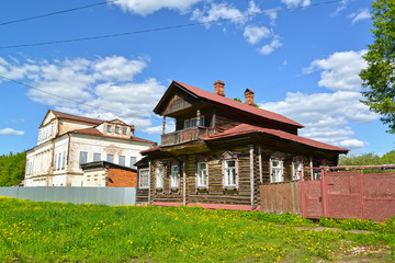 Fototapeta na wymiar Wooden house with the mezzanine and the stone mansion of the 19th century. Uglich, Yaroslavl region