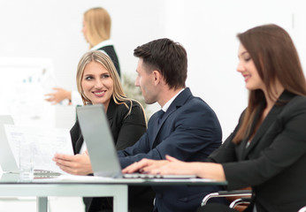 business team discussing new information , standing in front of the open laptop