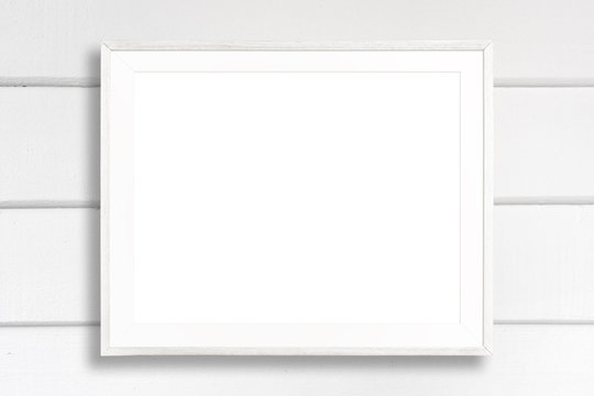 Blank White Picture Frame On White Wood Background.