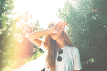 Close-up young woman hide her face from sun
