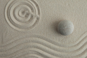 Pyramids of gray zen stones on the sand with wave drawings. Concept of harmony, balance and meditation, spa, massage, relax