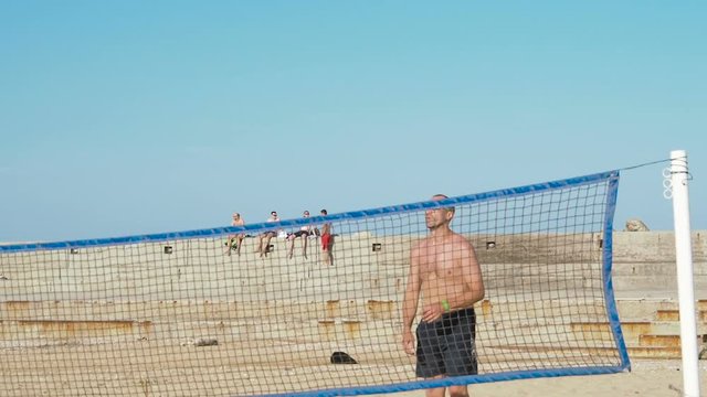 Friends are playing volleyball on the beach.