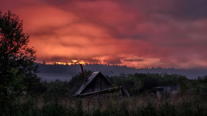 Vinous drama of the sky in dense dawn clouds. Perm region. Peremskoe village.