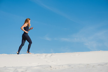 Pretty young female jogging in the desert
