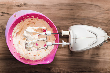 whipped butter, bowl with butter and whisk for beating on a wooden table, mixer