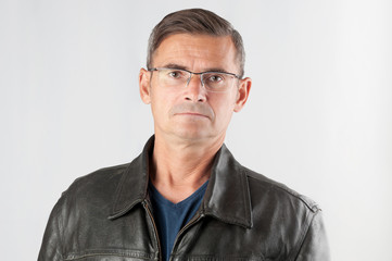 Portrait of mature man in eyeglasses on gray background
