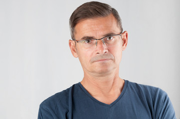 Portrait senior man in eyeglasses on gray background