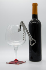 bottle of wine with corkscrew and glass