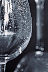 Closeup on two empty wine glasses with condensation on the side of the glass against a dark background