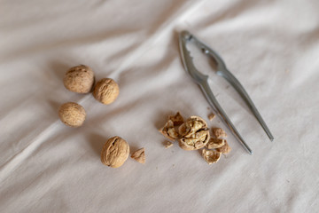 Nutcracker and walnuts in a bowl on a table covered with a tablecloth. Snack on the kitchen table.