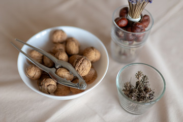 Nutcracker and walnuts in a bowl on a table covered with a tablecloth. Snack on the kitchen table.