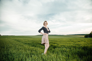 Young girl in a green field. Stylish girl. Green grass and blue sky. Emotional woman. plener. Travel. trip.