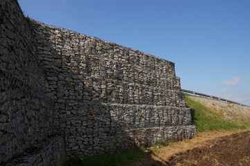 Securing the road. A huge retaining wall, designed to stabilize the ground made of gabions.