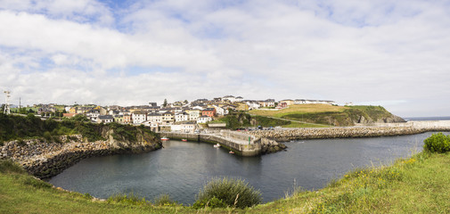 Fototapeta na wymiar Vista panorámica del Puerto de Vega, en Asturias, con el pueblo al fondo y el agua tranquila, en el verano de 2018