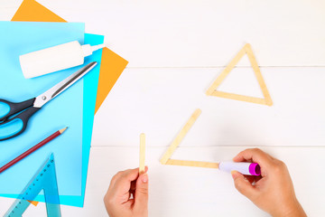 DIY. Star of David with his hands from ice cream sticks on a white wooden table.