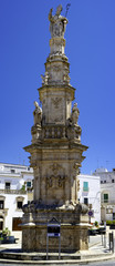 Fototapeta na wymiar A wide angle shot of the Tower of St. Horace (Guglia di Sant Oronzo) in Piazza della Liberta square