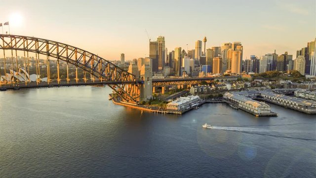 4k hyperlapse drone lapse of Sydney city skyline during sunrise. Aerial view with cinematic establishing shot and flare effect.