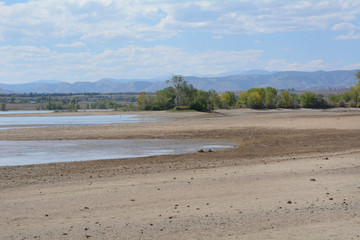 Increase of dry beach land with decreasing water level at Lake Standley reservoir in Westminster Colorado