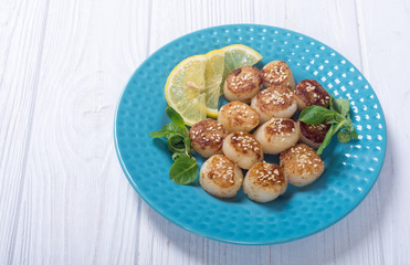 Fried scallops with lemon and salad