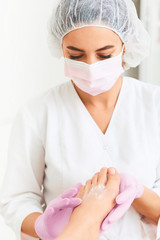 Professional foot massage using moisturizing foam.Final stage of professional pedicure.Skin...