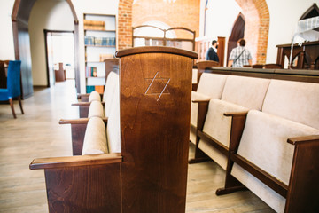 Star of David, Jewish symbol on wooden bench or chair in synagogue - obrazy, fototapety, plakaty
