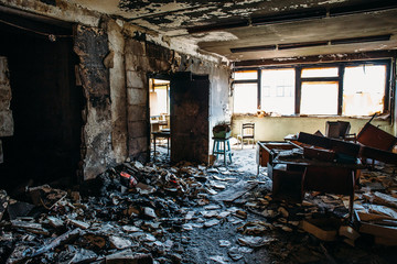 Burnt house interior. Burned room in industrial building, charred furniture and damaged apartment after fire