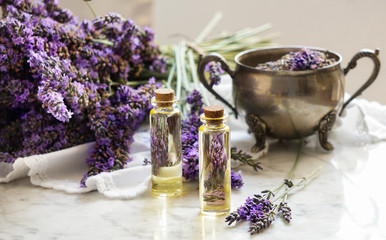 lavender oil bottles,  natural herb cosmetic consept with lavender flowers flatlay on stone background