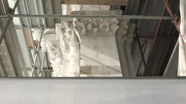 Renovation on the 11th century St. Martin dome, Lucca, capital and scaffolding. Restoration of famous church facade, exterior restoring works, conservation of old building in Tuscany, Italy