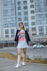 Obraz premium Beautiful woman with nude legs walking around city street wearing long white shirt