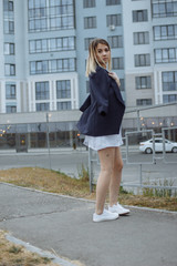 Obraz premium Beautiful woman with nude legs walking around city street wearing long white shirt