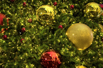 Close up background image of decorated outdoor Christmas tree with colorful lights and ornaments