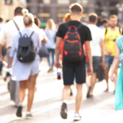 people take a leisurely walk through the summer sunny city, a blurred background