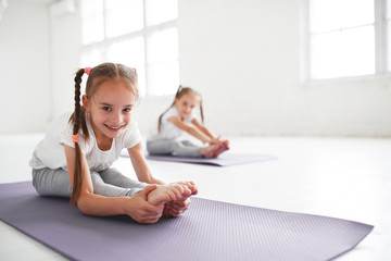 children girls doing yoga and gymnastics in gym