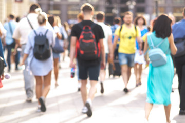 people take a leisurely walk through the summer sunny city, a blurred background