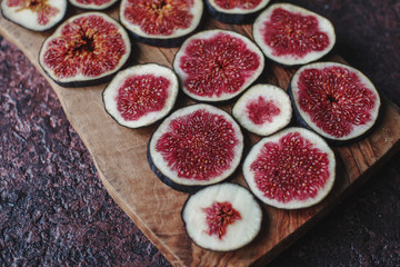 Obraz na płótnie Canvas Fresh organic ripe figs on rustic wooden board. Healthy lifestyle, seasonal fruit, sweet dessert, selective focus