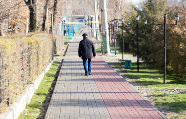 a man walking in the path of the sidewalk