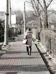 Girl walking on the path of the sidewalk