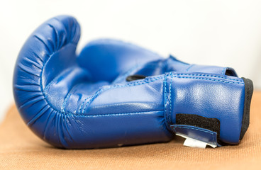 Blue boxing gloves on a brown background fabric